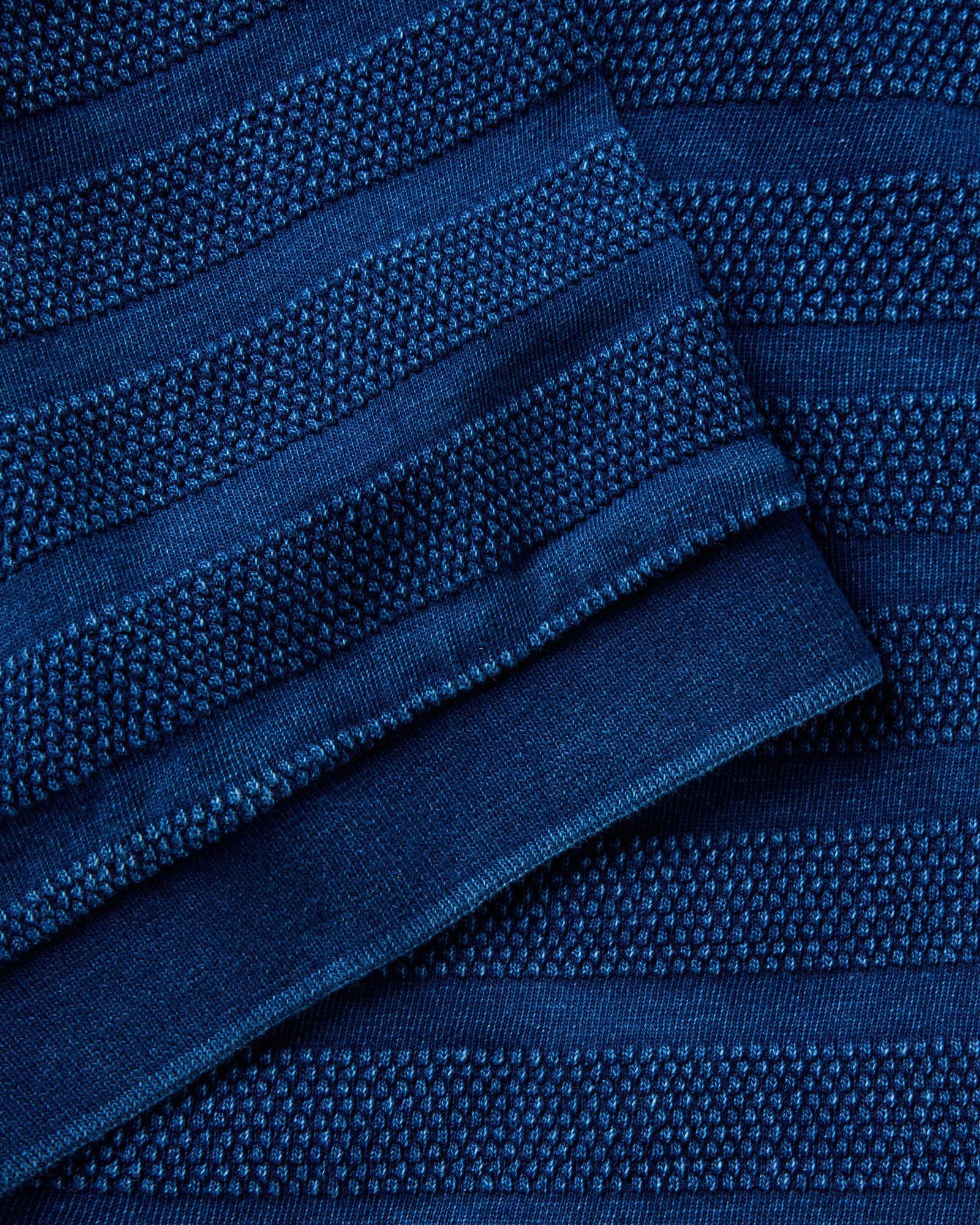 material shot of the sleeve on The Bywater Polo in Rinsed Indigo Knit Stripe, Knits by Taylor Stitch
