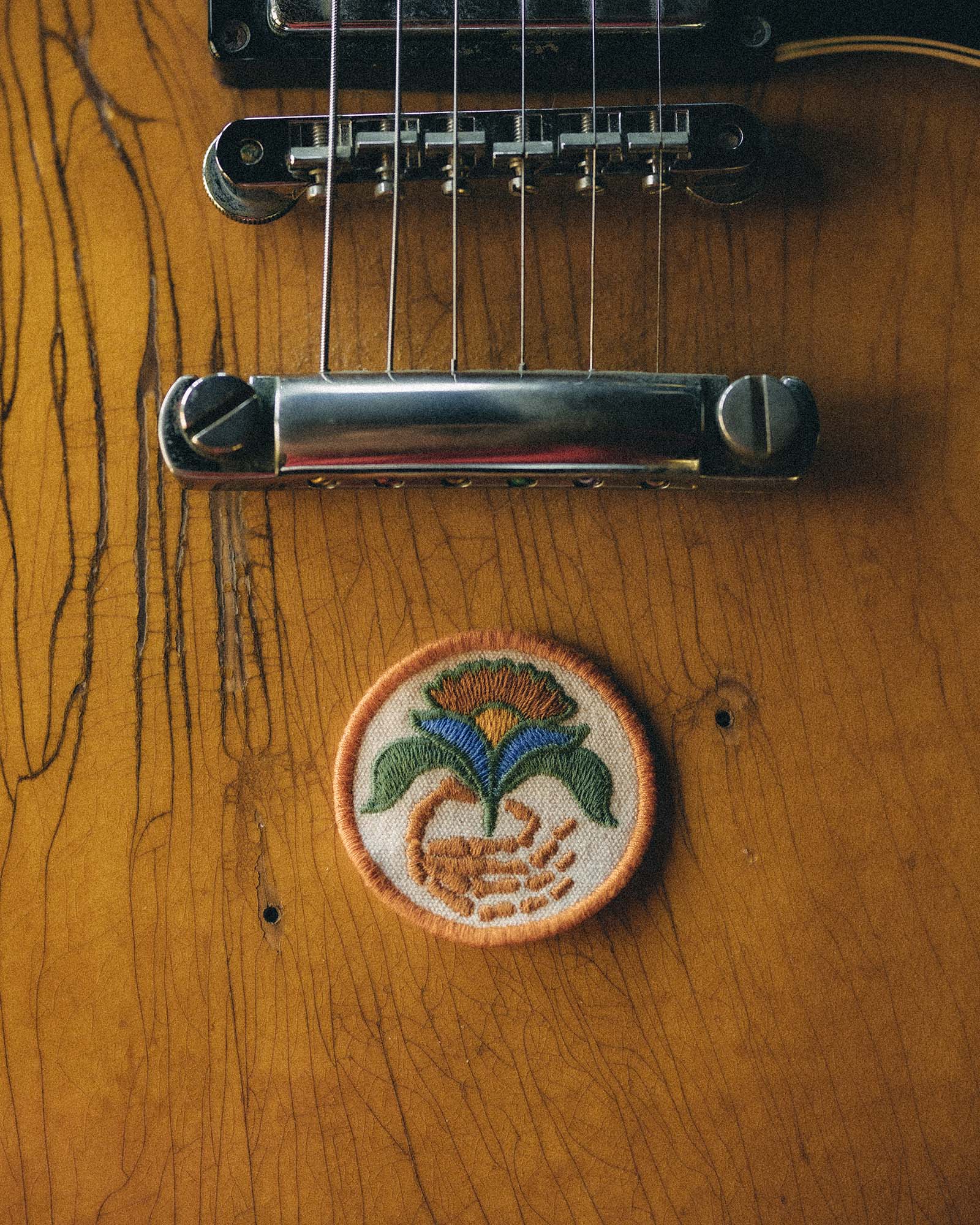 Embroidered patch with floral design on a wooden surface, Accessories by Taylor Stitch