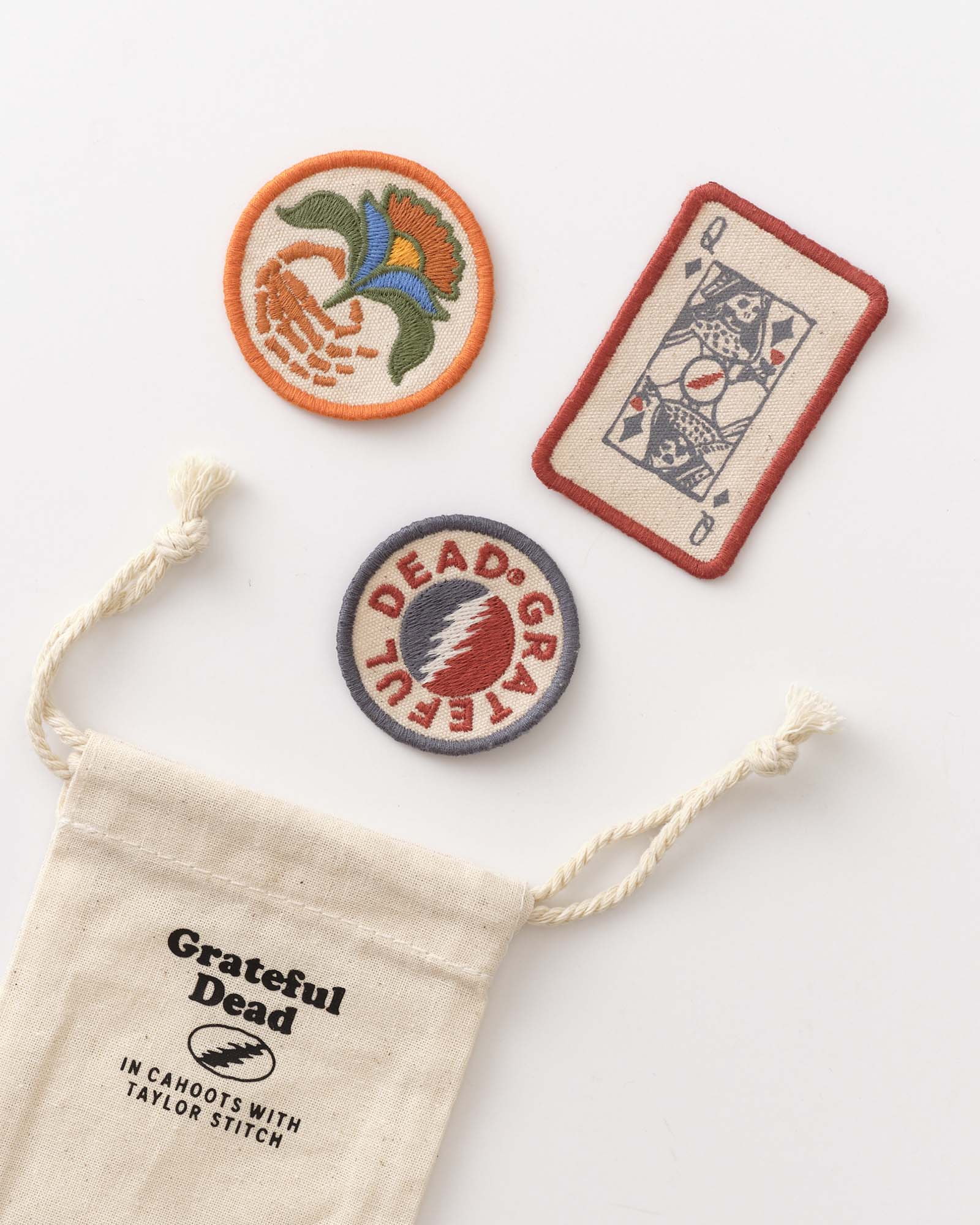 Three embroidered patches on a white background with a 'Grateful Dead' drawstring bag., Accessories by Taylor Stitch