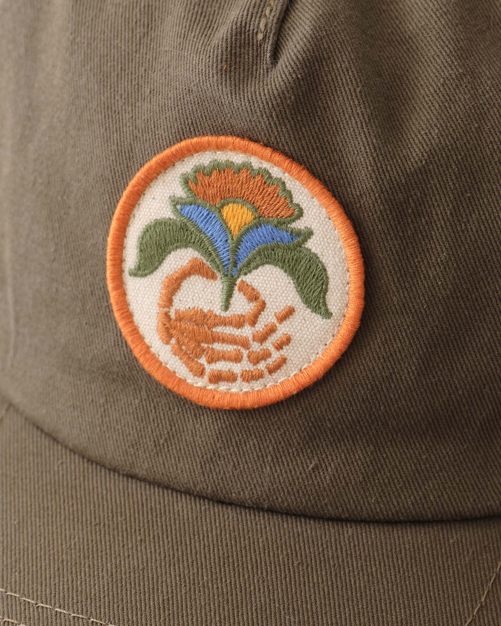 editorial image of the patch on The Mercer Cap in Bud Green Twill, Accessories by Taylor Stitch