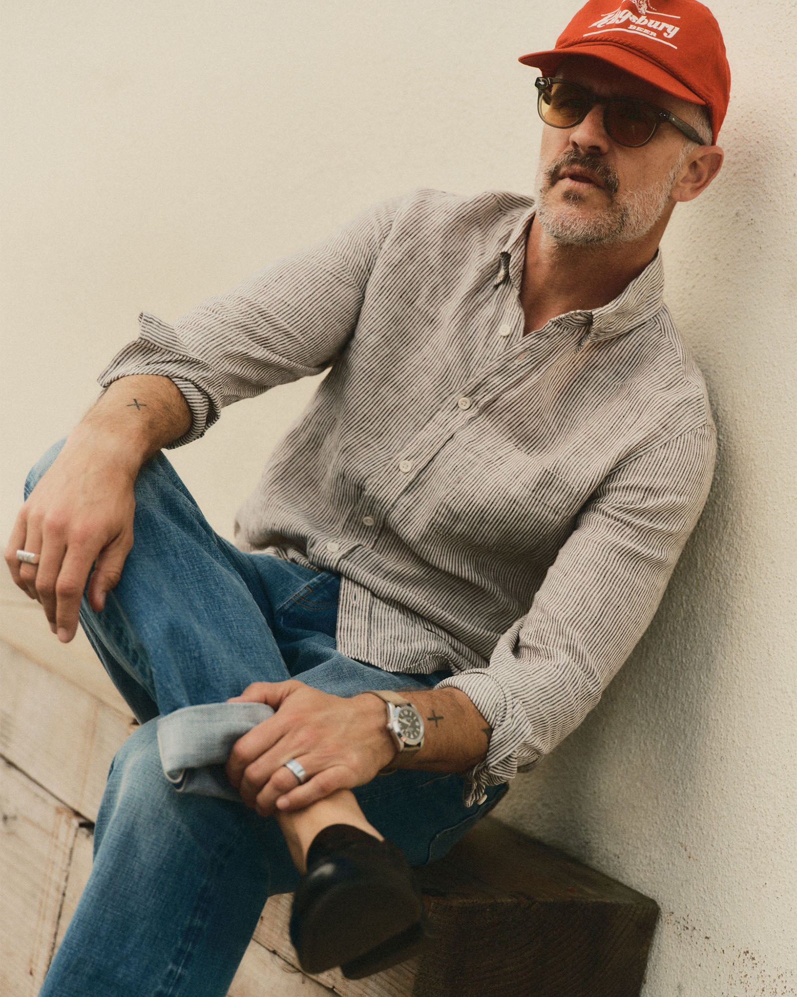 fit model sitting wearing The Jack in Burgundy University Stripe Linen, Wovens by Taylor Stitch