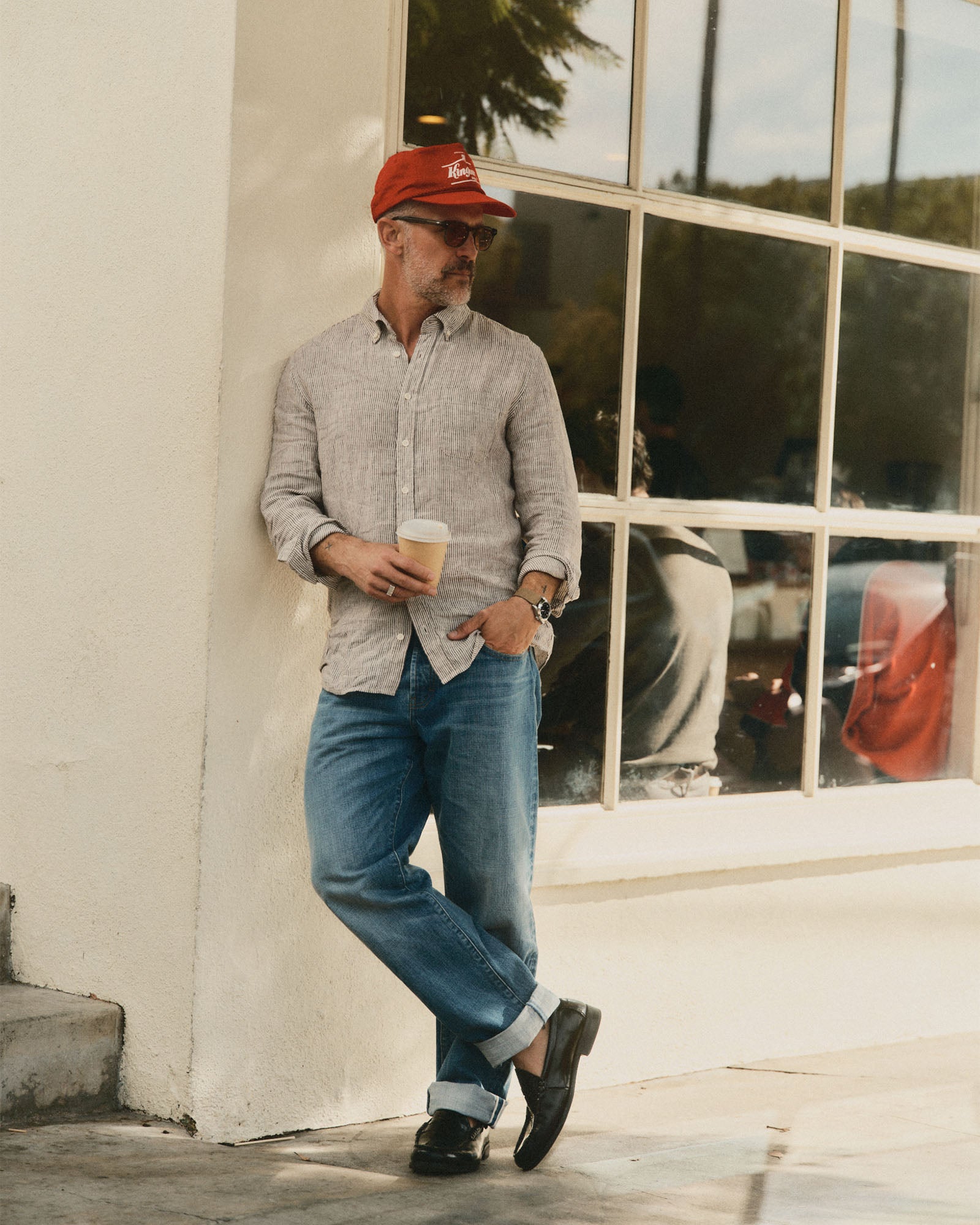 fit model leaning against the wall wearing The Jack in Burgundy University Stripe Linen, Wovens by Taylor Stitch