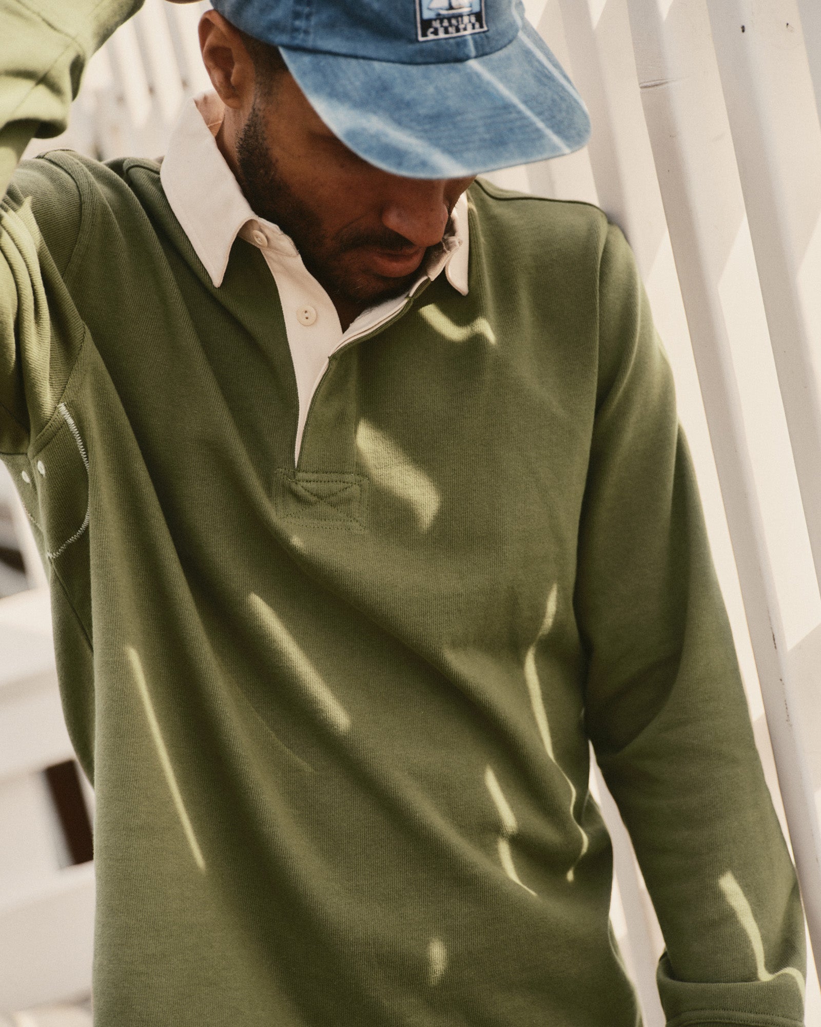 fit model posing in The Rugby Shirt in Burnt Olive, Knits by Taylor Stitch