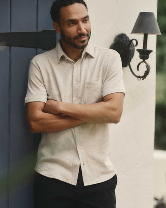 fit model leaning against the wall wearing The Short Sleeve California in Heather Oat Double Knit
