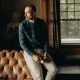 fit model leaning against a brown leather chair in The Colton Crew in Dark Forest Stripe