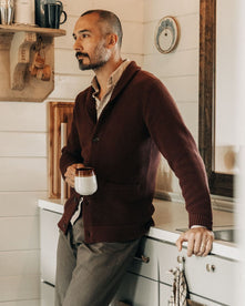 fit model leaning against the counter wearing The Crawford Sweater in Black Cherry