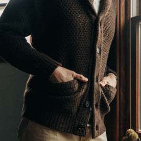 fit model with his hands in the pockets of The Fisherman Shawl Cardigan in Marsh Heather