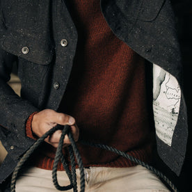 fit model holding a rope and wearing The Long Haul Jacket in Peat Nep Herringbone