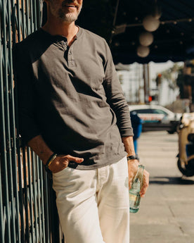 fit model posing in The Organic Cotton Henley in Faded Black, Knits by Taylor Stitch