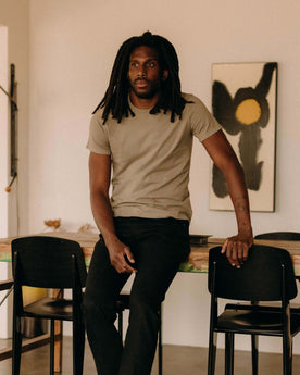 fit model sitting leaning against the wall in The Organic Cotton Tee in Sage, Knits by Taylor Stitch
