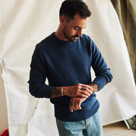 fit model adjusting watch wearing The Russell Sweater in Heather Blue