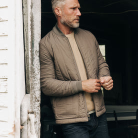 fit model adjusting his sleeves in The Able Jacket in Morel Quilted Nylon