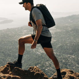 fit model hiking wearing The Challenge Cargo Short in Black