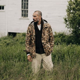 fit model standing in a field in The Explorer Jacket in Vintage Arid Camo Dry Wax