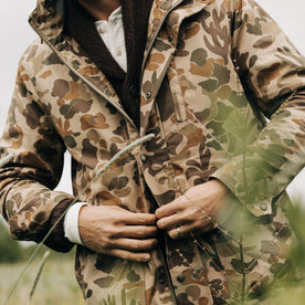 fit model buttoning The Explorer Jacket in Vintage Arid Camo Dry Wax