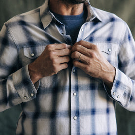 fit model buttoning The Frontier Shirt in Indigo Shadow Plaid