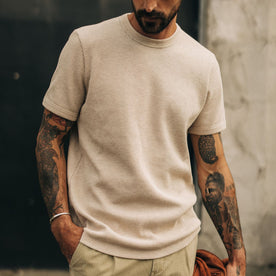 fit model with his hand in his pocket wearing The Heavy Bag Waffle Short Sleeve in Oat Heather