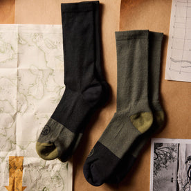 flatlay of The Merino Sock in Black next to other socks