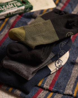 editorial image of The Merino Sock in Olive and other socks stacked on top of each other, Accessories by Taylor Stitch