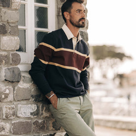 fit model leaning against the wall wearing The Rugby in Dark Navy Stripe