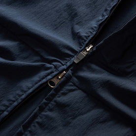 material shot of the zipper on The Deploy Packable Shell in Dark Navy
