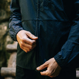 fit model zipping up The Deploy Packable Shell in Dark Navy