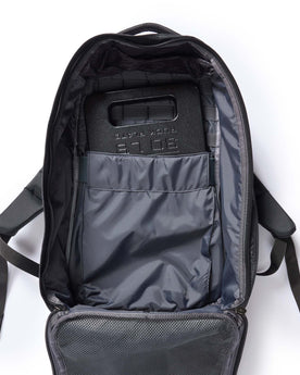 flatlay of the inside of The GR1 USA in Raindrop Camo Ripstop WashWax with a weight in the pocket, Accessories by Taylor Stitch