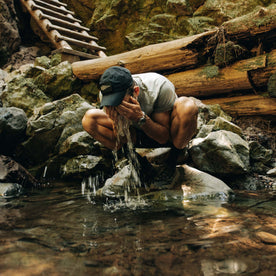 fit model splashing water on his face wearing The Performance TAC Hat in Black