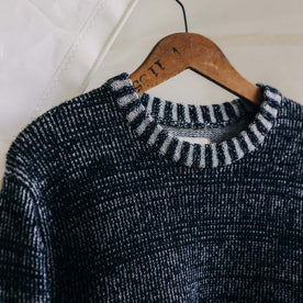 The Headland Sweater in Coal Heather on a hanger