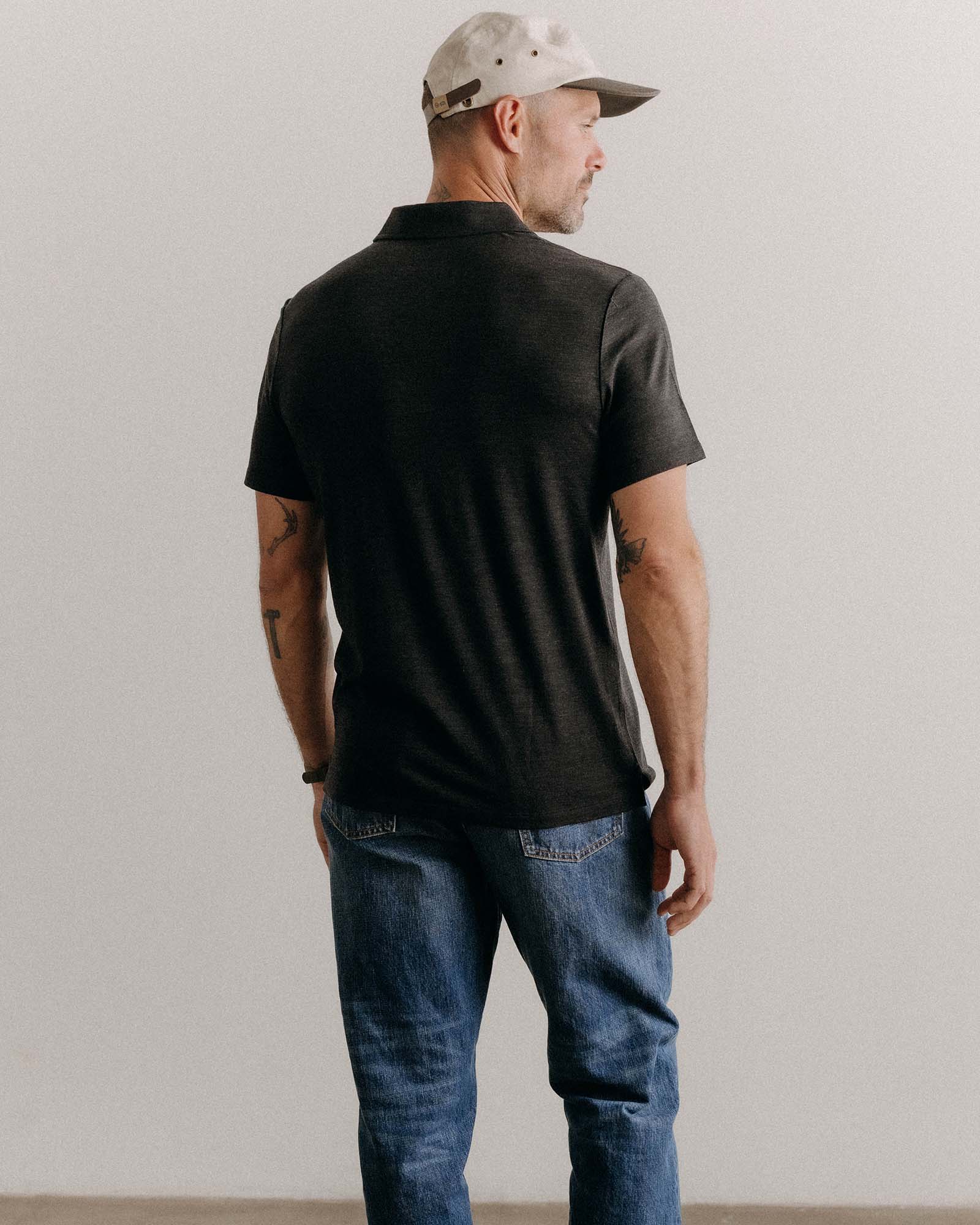 fit model sitting wearing The Merino Polo in Heather Black, Knits by Taylor Stitch