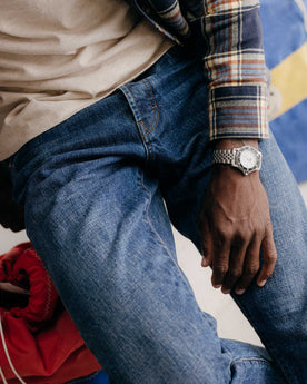 fit model sitting wearing The Democratic Jean in Mid Wash Organic Selvedge, Bottoms by Taylor Stitch