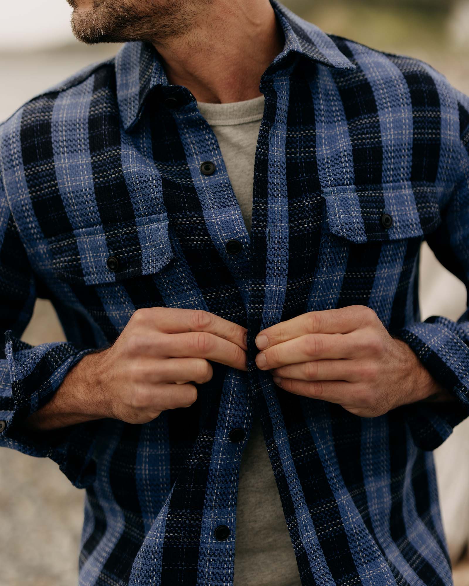 fit model with his shirt open wearing The Division Shirt in Rinsed Indigo Plaid, Wovens by Taylor Stitch