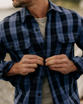 fit model with his shirt open wearing The Division Shirt in Rinsed Indigo Plaid, Wovens by Taylor Stitch