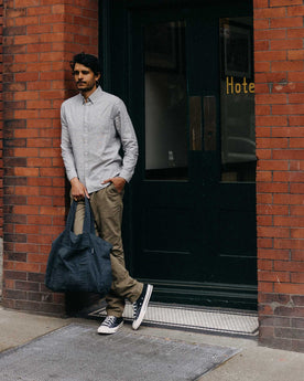 fit model leaning against the wall wearing The Foundation Tote in Organic Navy, Accessories by Taylor Stitch