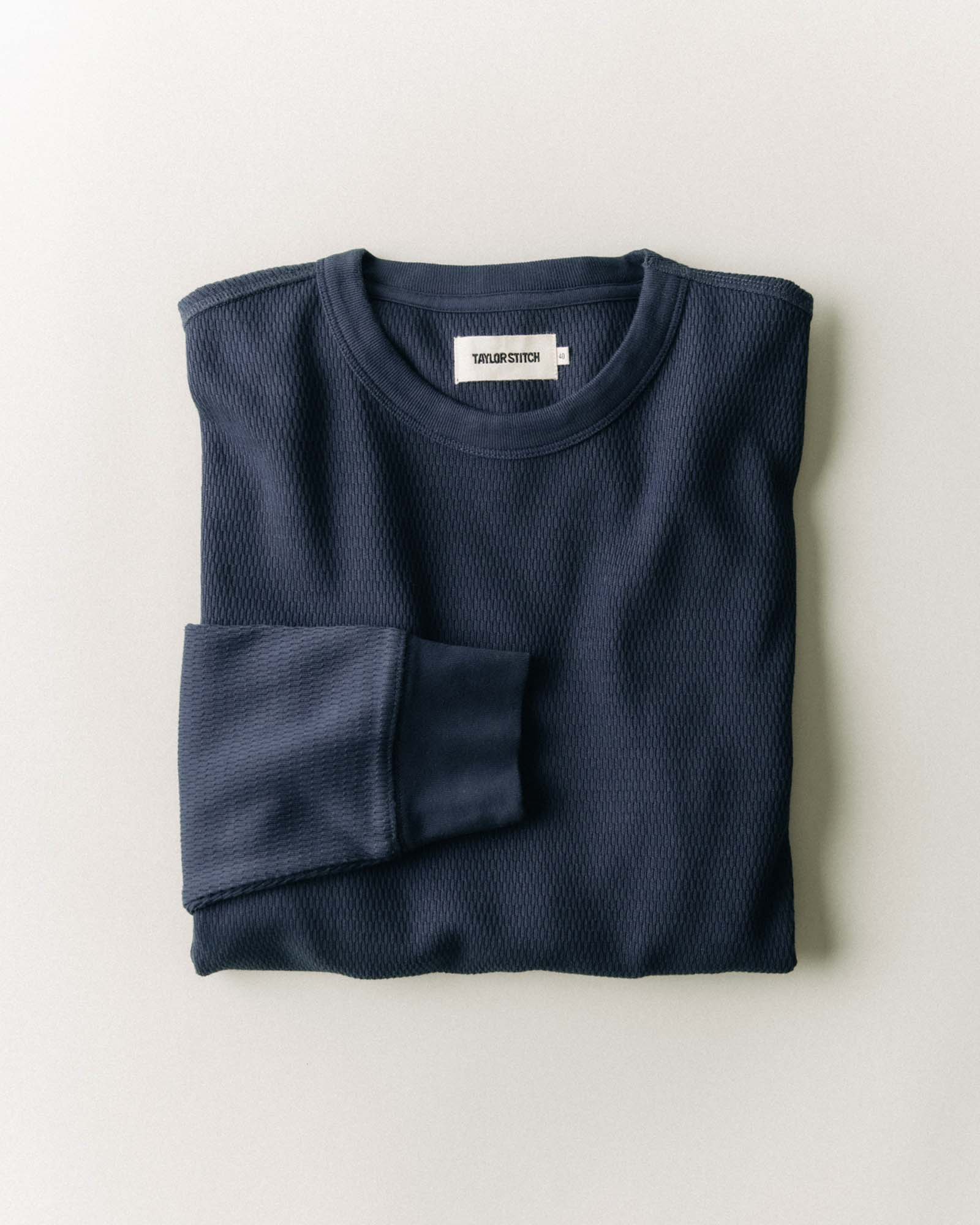 fit model leaning against a roof in The Organic Cotton Waffle Crew in Dark Navy, Knits by Taylor Stitch