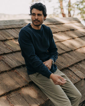 fit model leaning against a roof in The Organic Cotton Waffle Crew in Dark Navy, Knits by Taylor Stitch