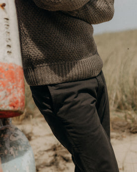 fit model standing in a field wearing The Slim Foundation Pant in Organic Faded Black, Bottoms by Taylor Stitch