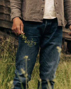 fit model holding plants wearing The Slim Jean in Mid Wash Organic Selvedge, Bottoms by Taylor Stitch