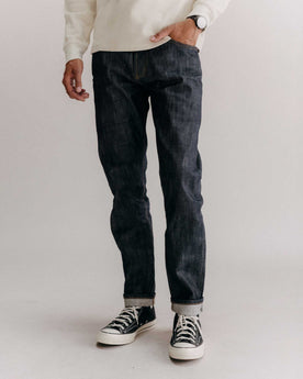 fit model with his hand in his pocket wearing The Slim Jean in Rigid Organic Selvedge, Bottoms by Taylor Stitch
