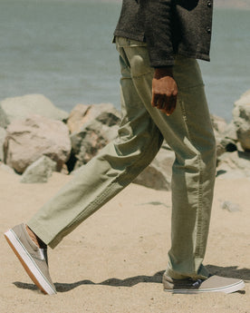 fit model walking on The Surplus Pant in Field Olive Reverse Sateen, Bottoms by Taylor Stitch