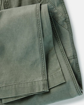 folded flatlay of the back of The Surplus Pant in Field Olive Reverse Sateen, Bottoms by Taylor Stitch