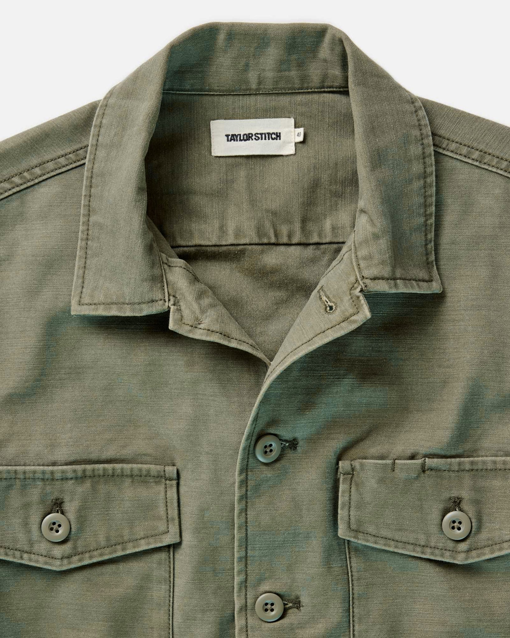 fit model sitting wearing The Surplus Shirt in Field Olive Reverse Sateen, Wovens by Taylor Stitch