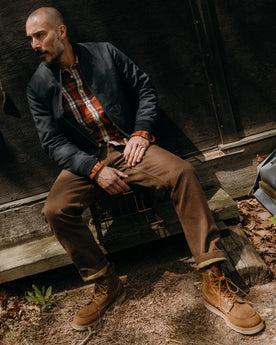 fit model leaning against the wall wearing The Camp Pant in Aged Penny Chipped Canvas, Bottoms by Taylor Stitch