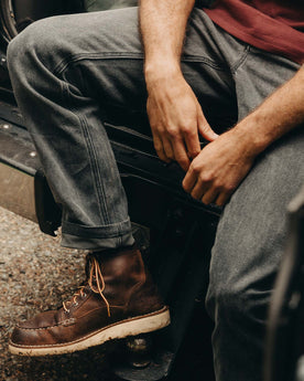 fit model sitting wearing The Camp Pant in Coal Chipped Canvas, Bottoms by Taylor Stitch