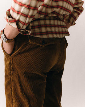 fit model sitting wearing The Carnegie Pant in Bourbon Corduroy, Bottoms by Taylor Stitch