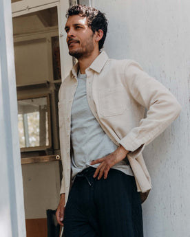 fit model leaning against the wall wearing The Utility Shirt in Natural Sashiko, Wovens by Taylor Stitch
