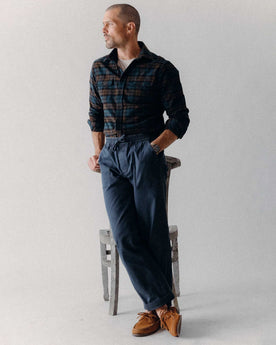 fit model leaning against a chair wearing The Breakwater Pant in Dark Navy Ripstop, Bottoms by Taylor Stitch