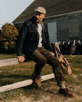 fit model sitting wearing The Carnegie Pant in Fatigue Olive Corduroy, Bottoms by Taylor Stitch