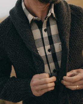 fit model buttoning up The Fisherman Shawl Cardigan in Heather Coal Merino, Knits by Taylor Stitch