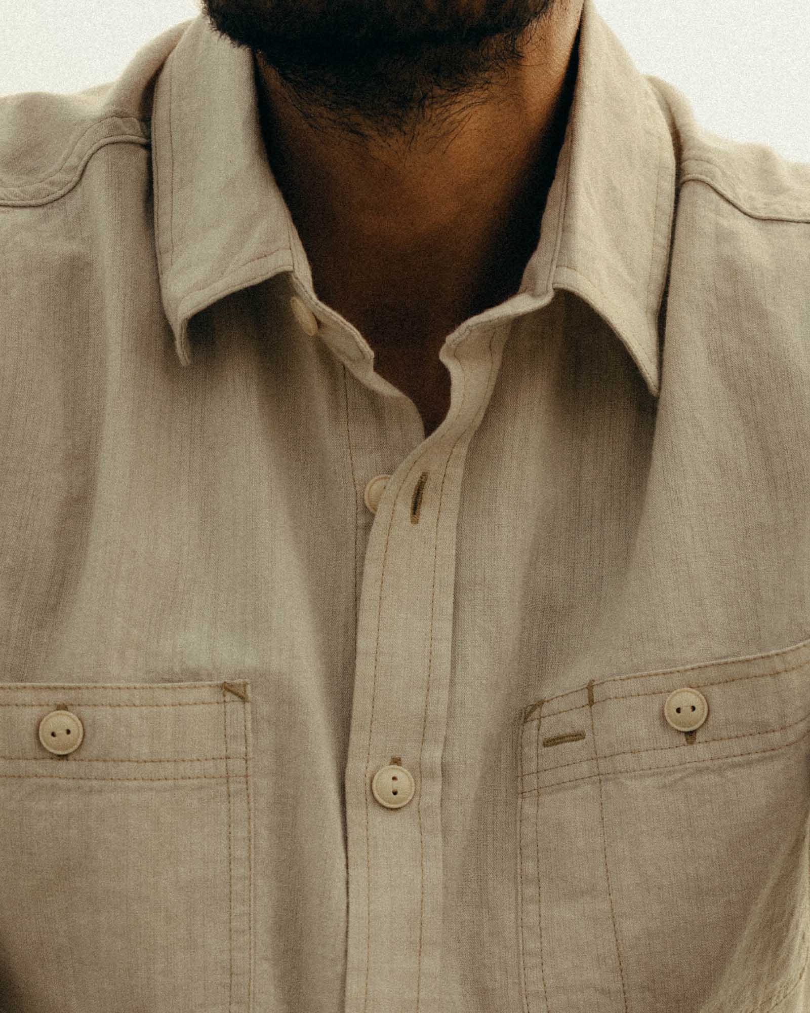 fit model showing off the buttons on The Foundry Shirt in Natural Chambray, Wovens by Taylor Stitch